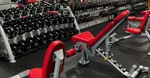 Free weight area with dumbbell racks and bench at Falmouth Sports Center